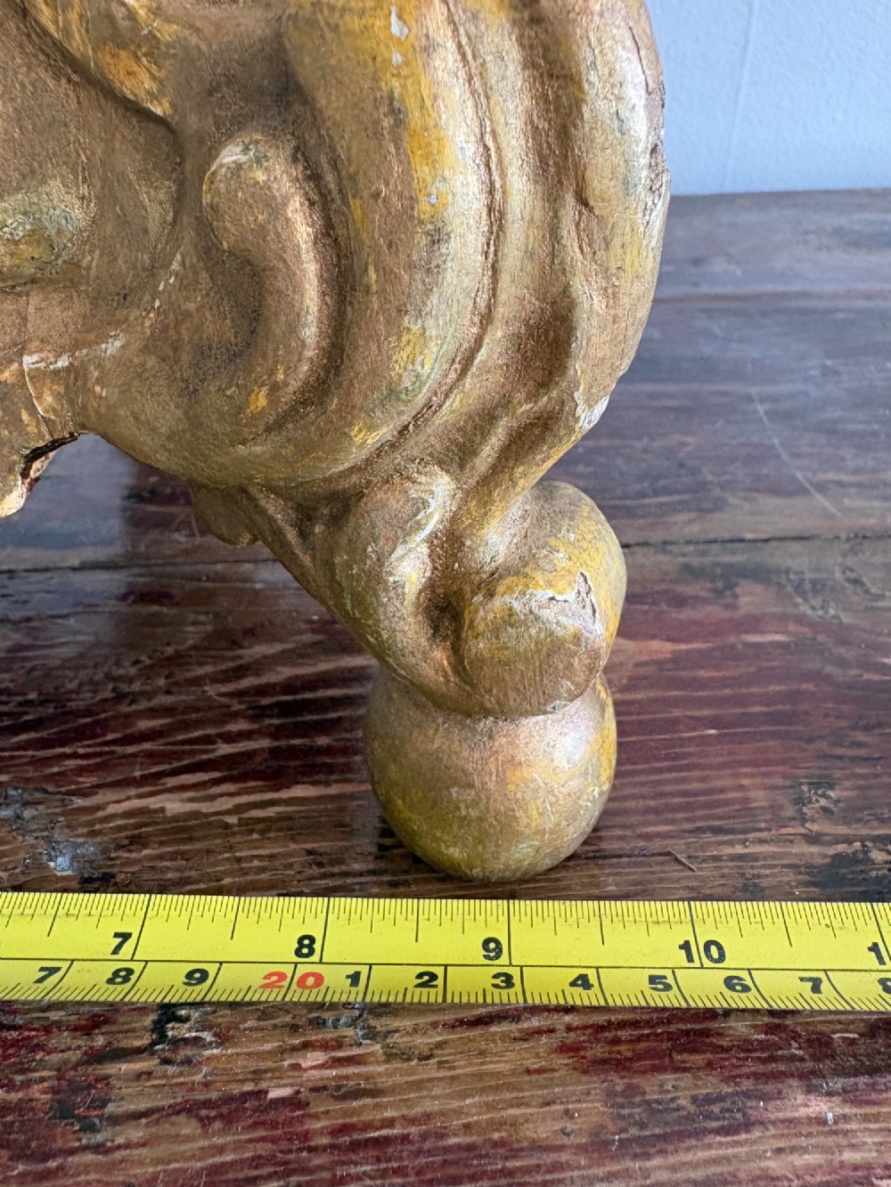 A pair of 18th-century Italian Baroque carved giltwood altar candlesticks featuring triform bases with scrollwork and tall baluster stems. View XIII