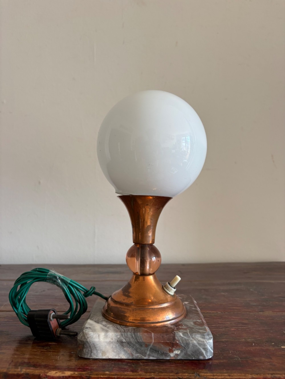 A small French Art Deco table lamp featuring a spherical white opaline glass shade atop a turned copper stem mounted on a square veined marble base. View II