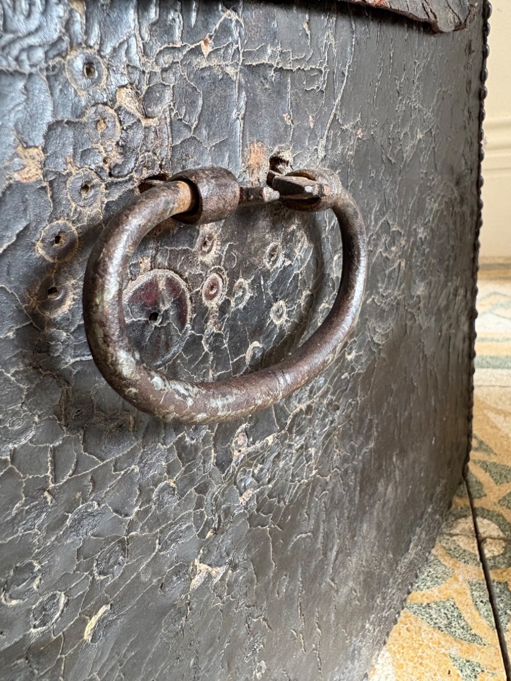 An 18th-century Dutch dark brown leather trunk featuring a domed lid, intricate brass studding in scrolling floral patterns, and iron lock hardware. View VIII