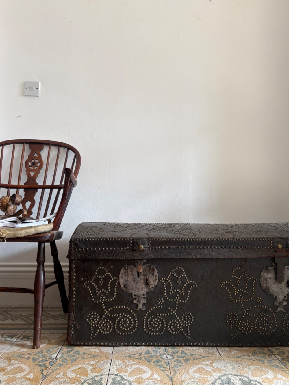 An 18th-century Dutch dark brown leather trunk featuring a domed lid, intricate brass studding in scrolling floral patterns, and iron lock hardware. View XI