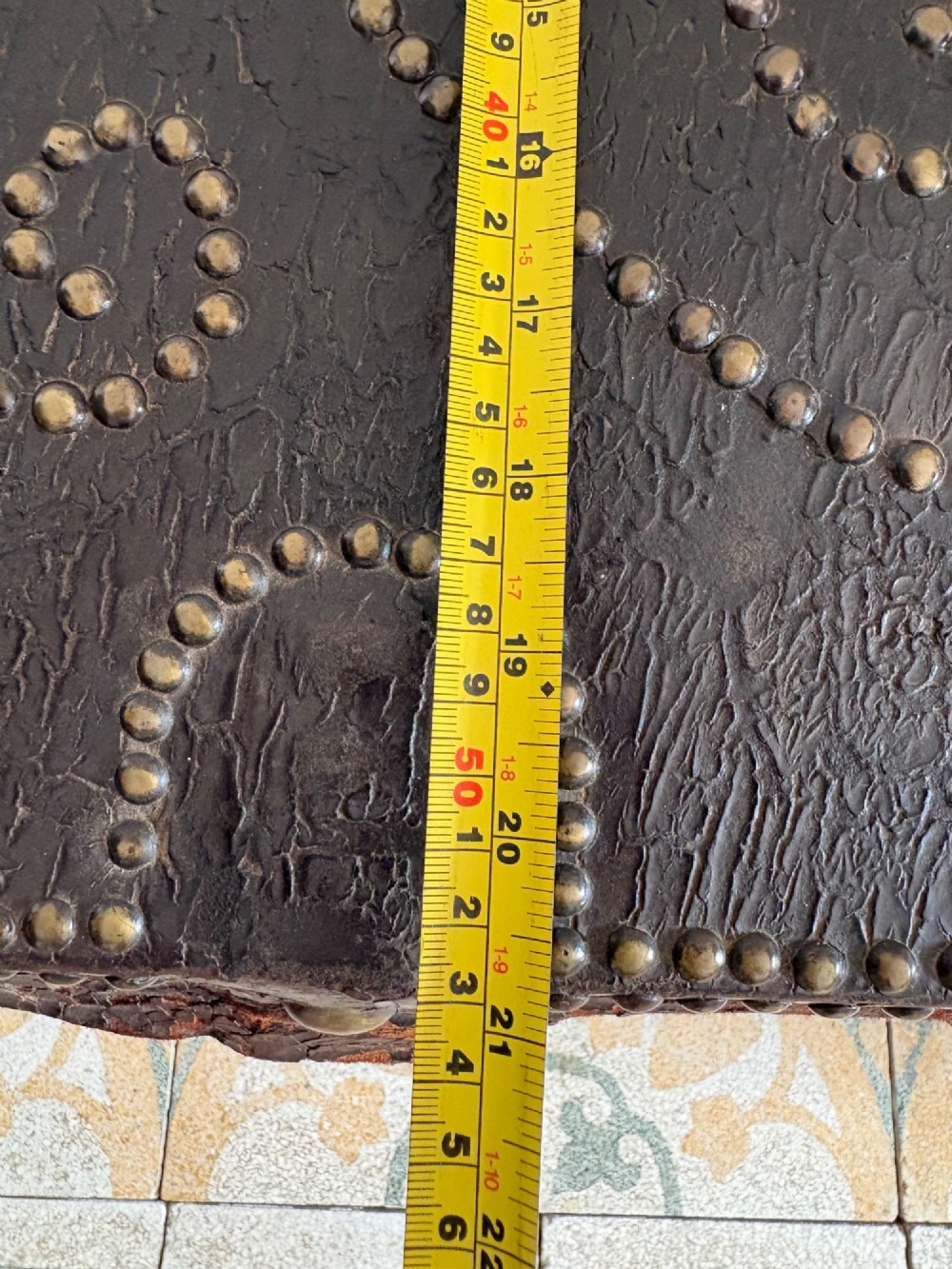 An 18th-century Dutch dark brown leather trunk featuring a domed lid, intricate brass studding in scrolling floral patterns, and iron lock hardware. View XIV