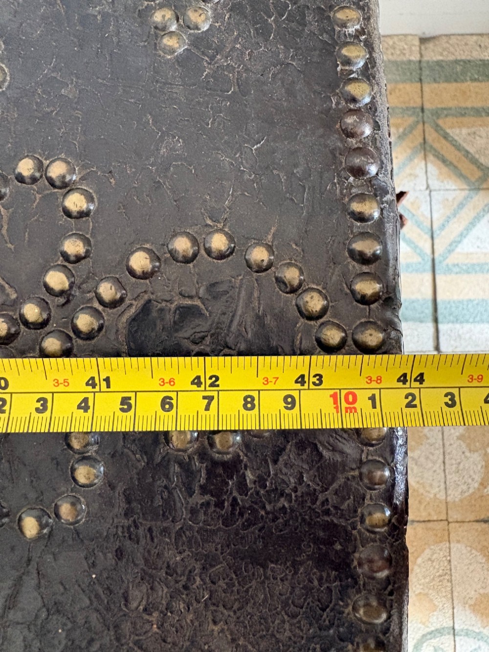 An 18th-century Dutch dark brown leather trunk featuring a domed lid, intricate brass studding in scrolling floral patterns, and iron lock hardware. View XV