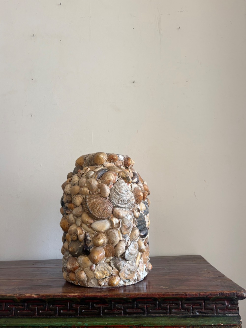 A cylindrical antique vase completely encrusted with an assortment of natural sea shells set into a mortar matrix. View XI