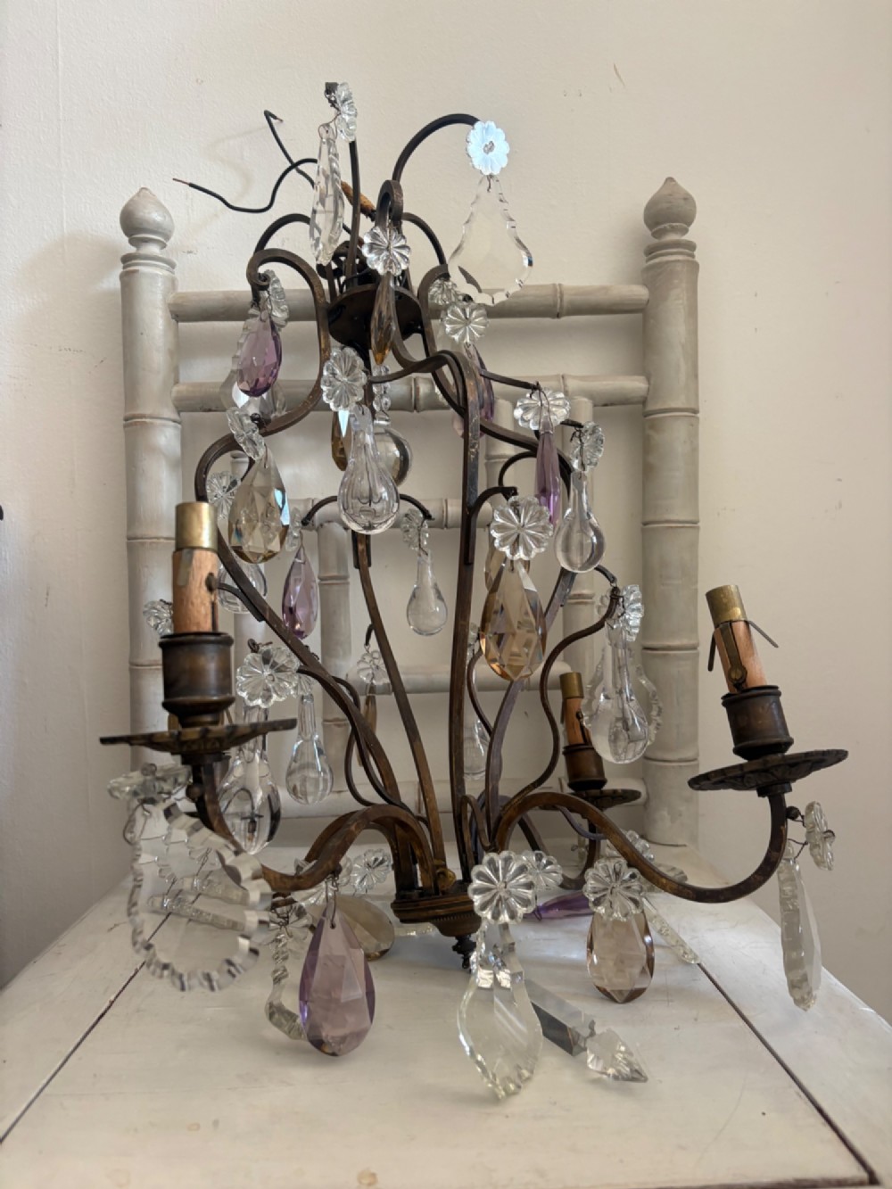 A four-branch French Rococo style gilt bronze chandelier decorated with clear, grey, and violet crystal drops. View III