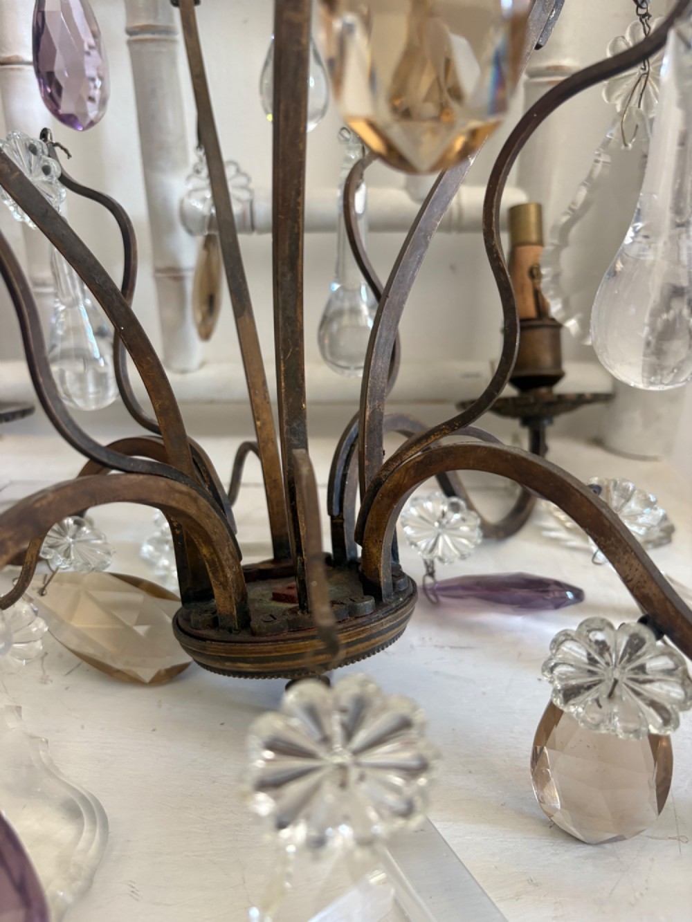 A four-branch French Rococo style gilt bronze chandelier decorated with clear, grey, and violet crystal drops. View V