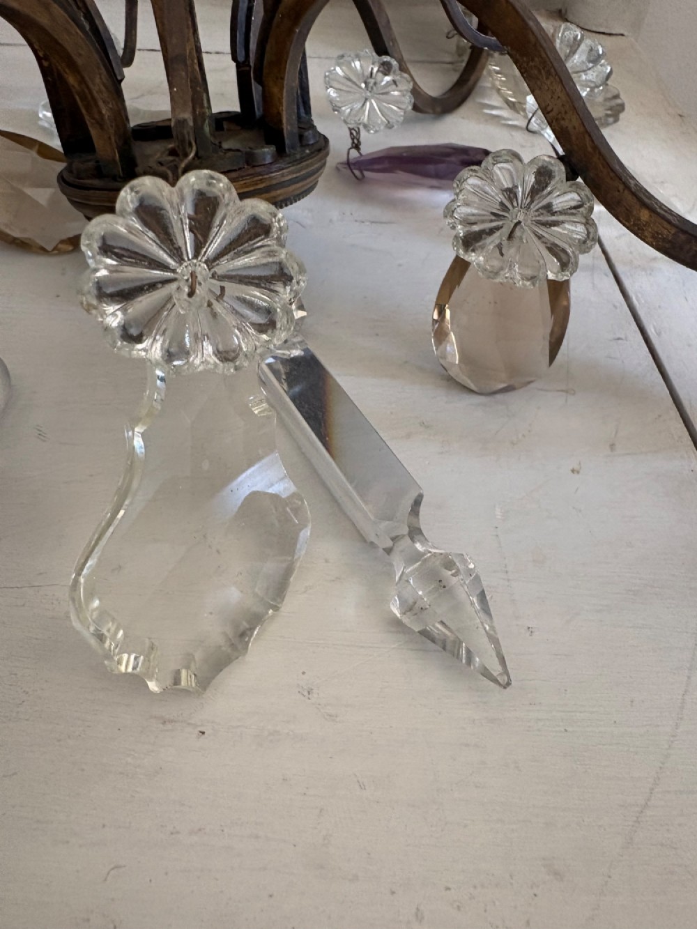 A four-branch French Rococo style gilt bronze chandelier decorated with clear, grey, and violet crystal drops. View VII