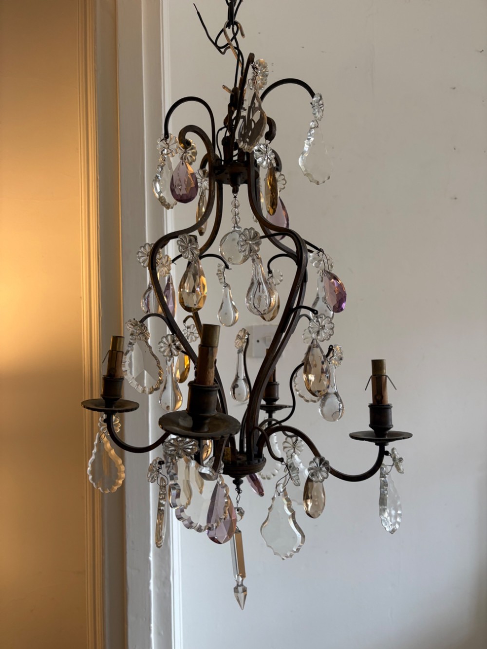 A four-branch French Rococo style gilt bronze chandelier decorated with clear, grey, and violet crystal drops. View XIV