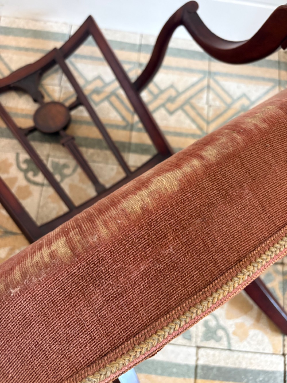 A late 18th-century Georgian mahogany open armchair featuring a carved back splat with a central rosewood roundel, swept armrests, and reddish-brown fabric upholstery. View VIII
