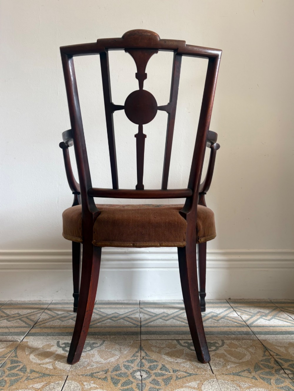 A late 18th-century Georgian mahogany open armchair featuring a carved back splat with a central rosewood roundel, swept armrests, and reddish-brown fabric upholstery. View XIV