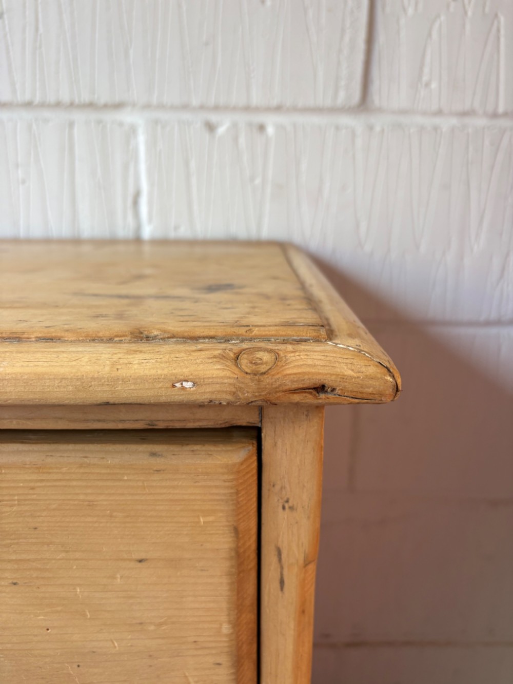 A nineteenth-century scrubbed pine chest of drawers with two small drawers above two long drawers featuring dark turned bun handles. View V