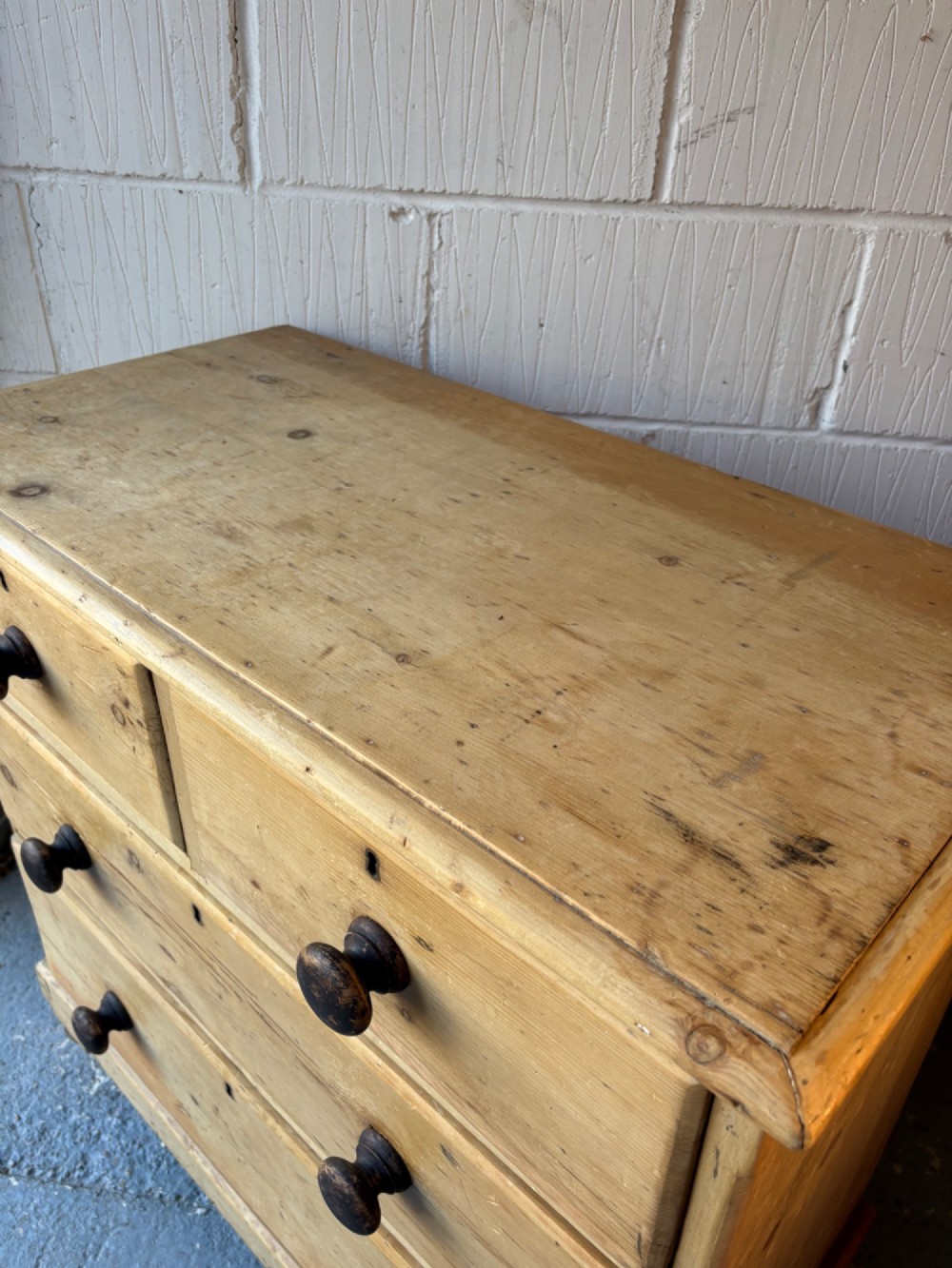 A nineteenth-century scrubbed pine chest of drawers with two small drawers above two long drawers featuring dark turned bun handles. View X