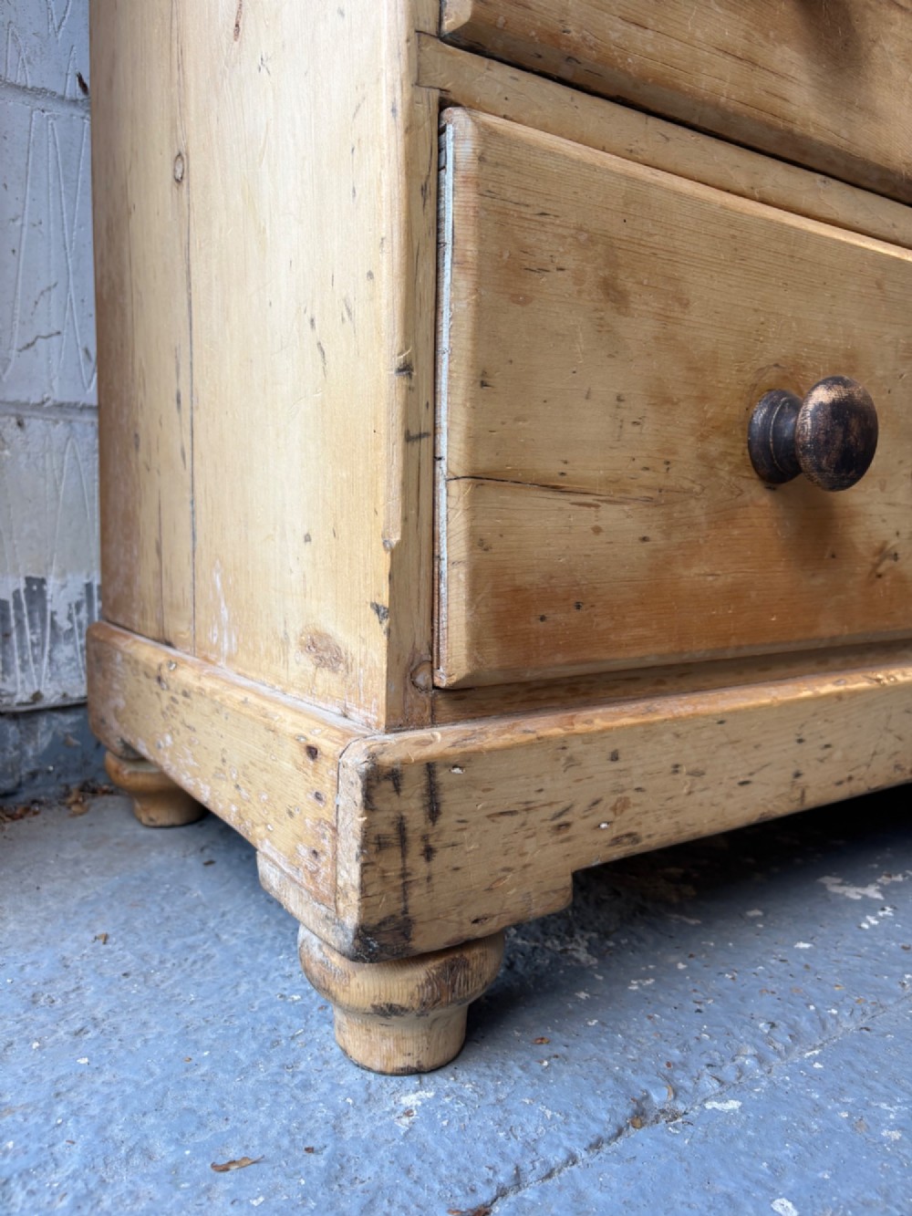 A nineteenth-century scrubbed pine chest of drawers with two small drawers above two long drawers featuring dark turned bun handles. View XI