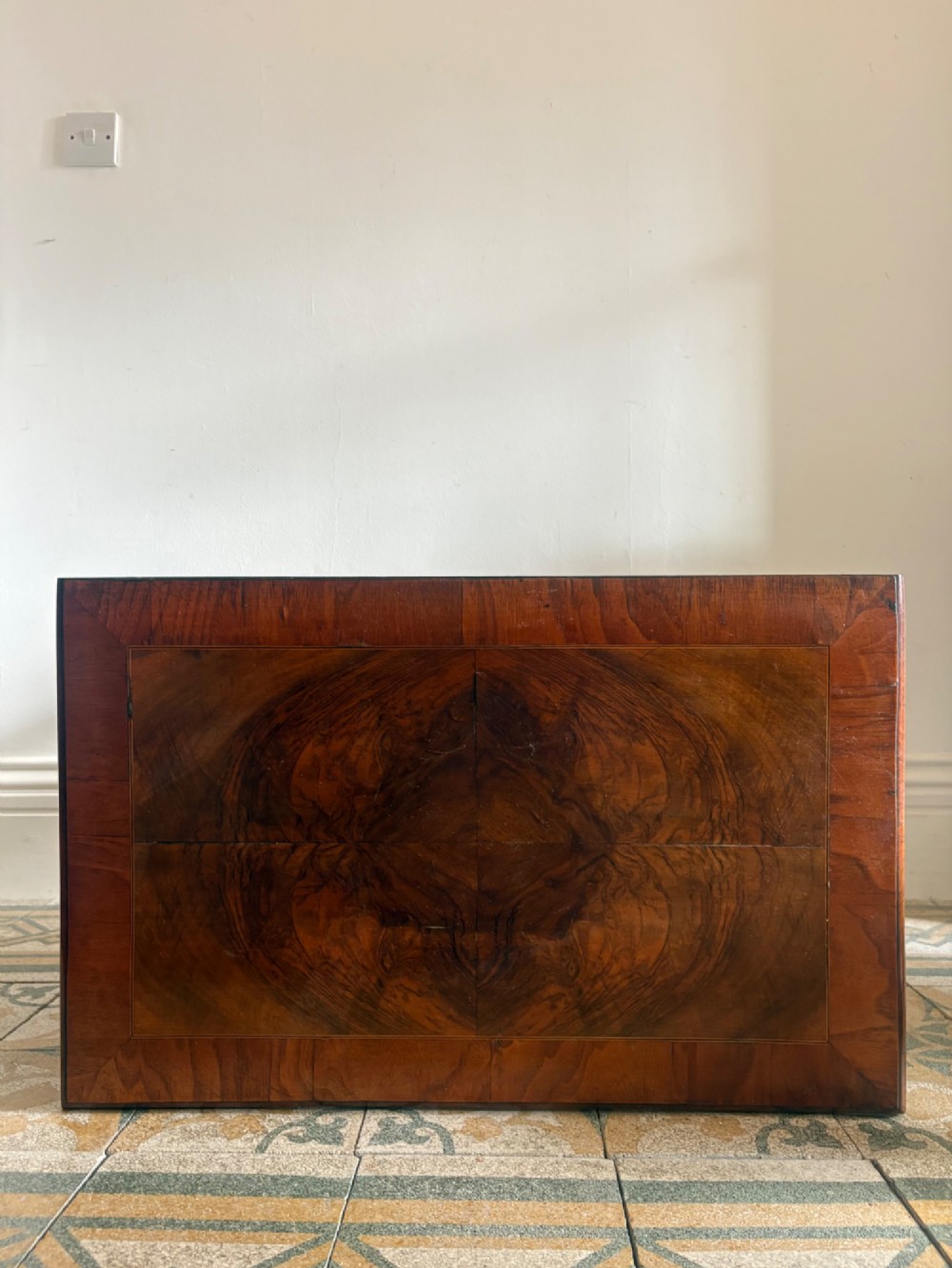An early 18th-century figured walnut lowboy side table featuring three drawers, a shaped apron, brass handles, and cabriole legs. View VI