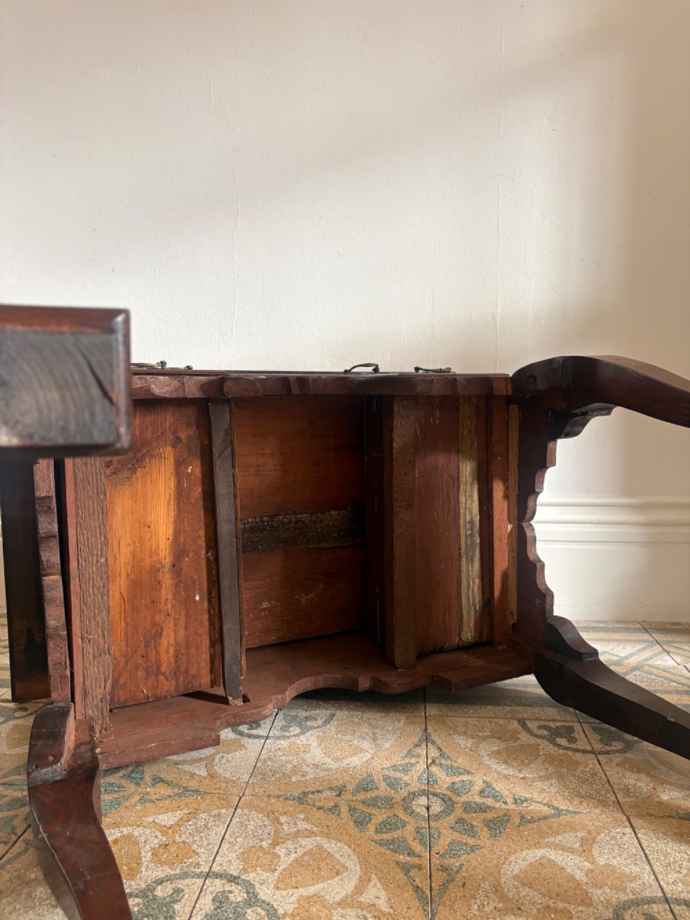 An early 18th-century figured walnut lowboy side table featuring three drawers, a shaped apron, brass handles, and cabriole legs. View VII