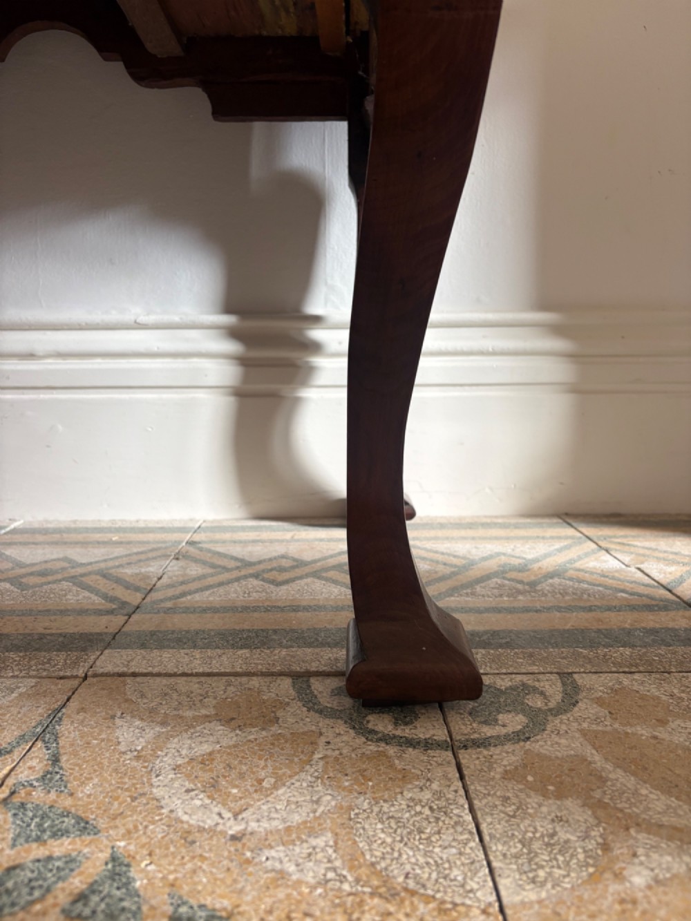 An early 18th-century figured walnut lowboy side table featuring three drawers, a shaped apron, brass handles, and cabriole legs. View XII
