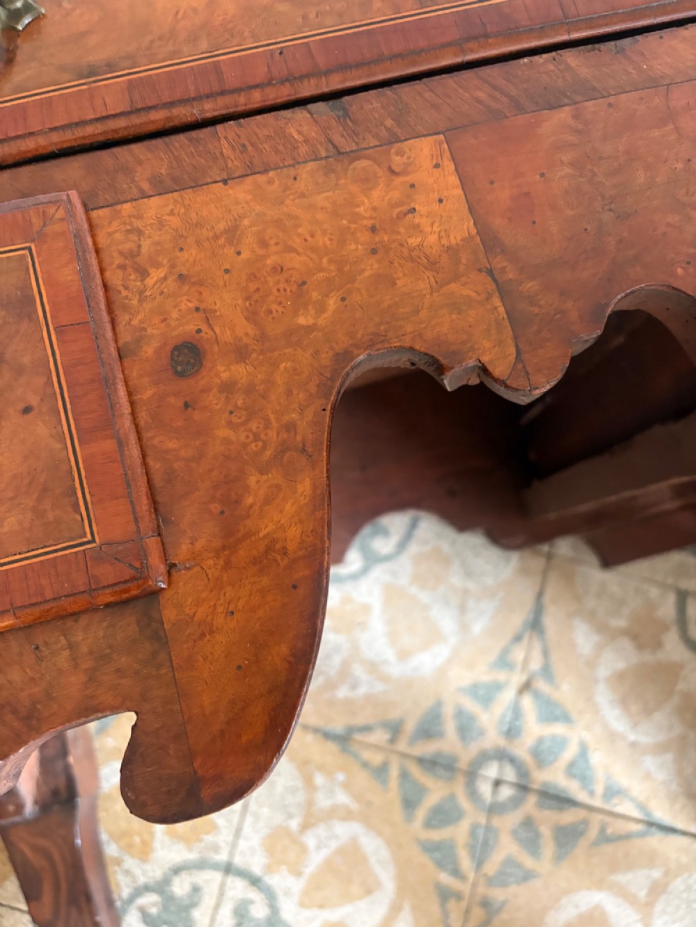 An early 18th-century figured walnut lowboy side table featuring three drawers, a shaped apron, brass handles, and cabriole legs. View XIII