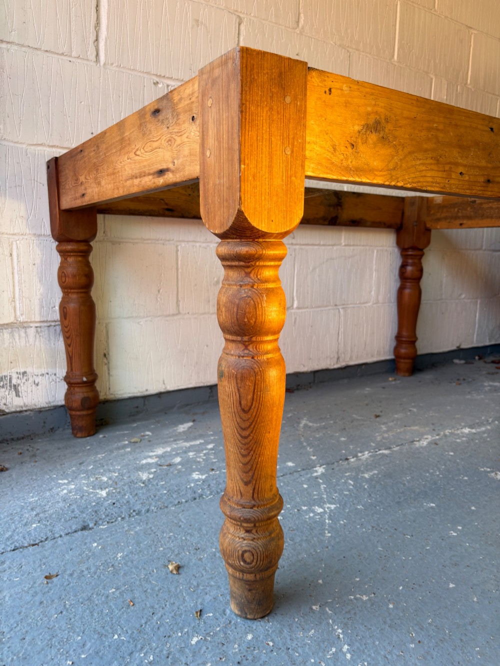 An Edwardian rectangular pine farmhouse kitchen table featuring turned elm legs and a thick wooden top. View III