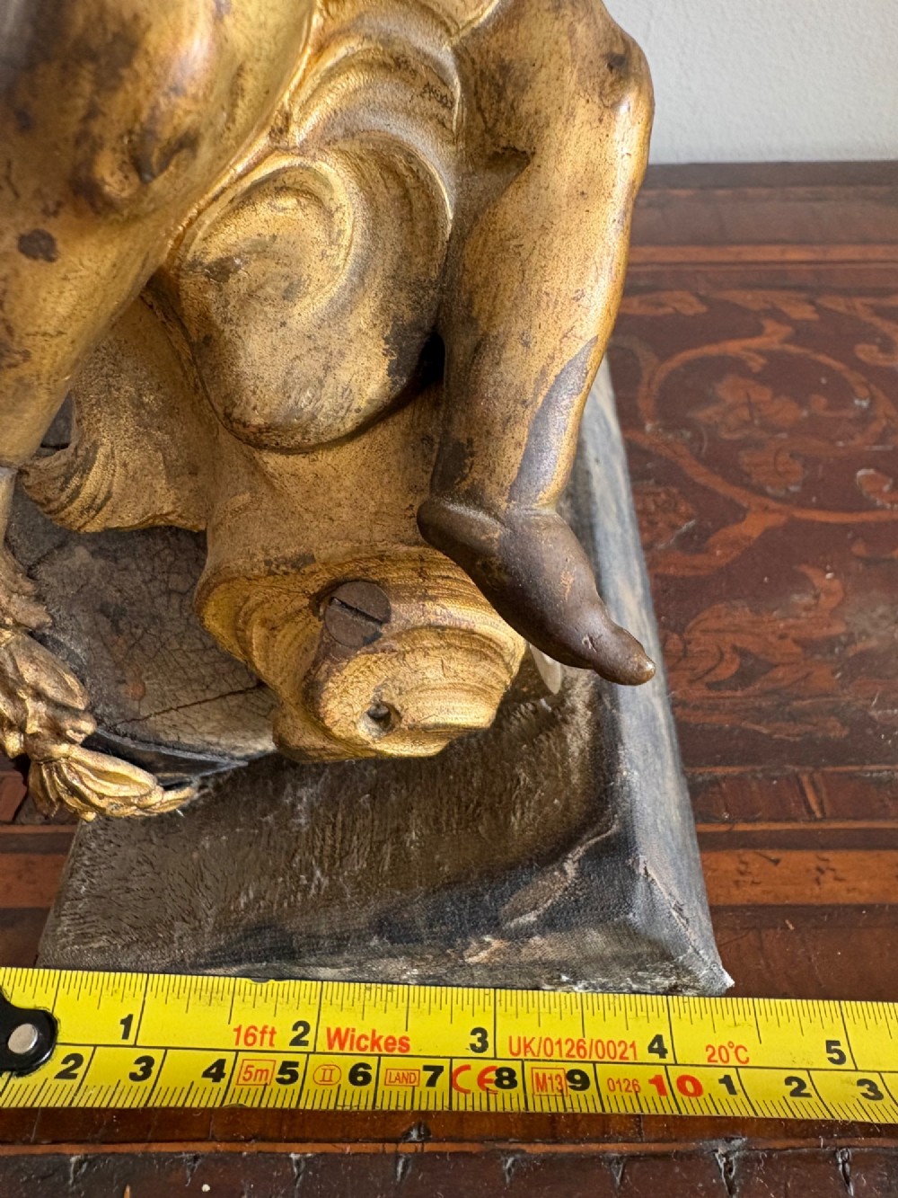 A late eighteenth or nineteenth-century French gilt bronze ormolu sculpture featuring a reclining putto holding a small vessel above a scrolled arch base. View XIII
