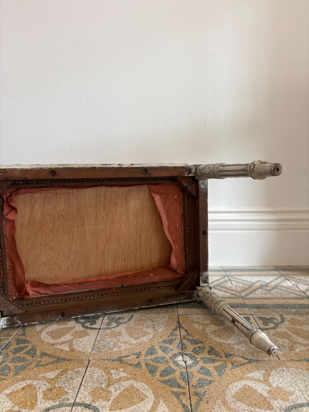 A white painted Gustavian style stool featuring raised side handles, fluted legs, and a terracotta silk upholstered seat. View XII