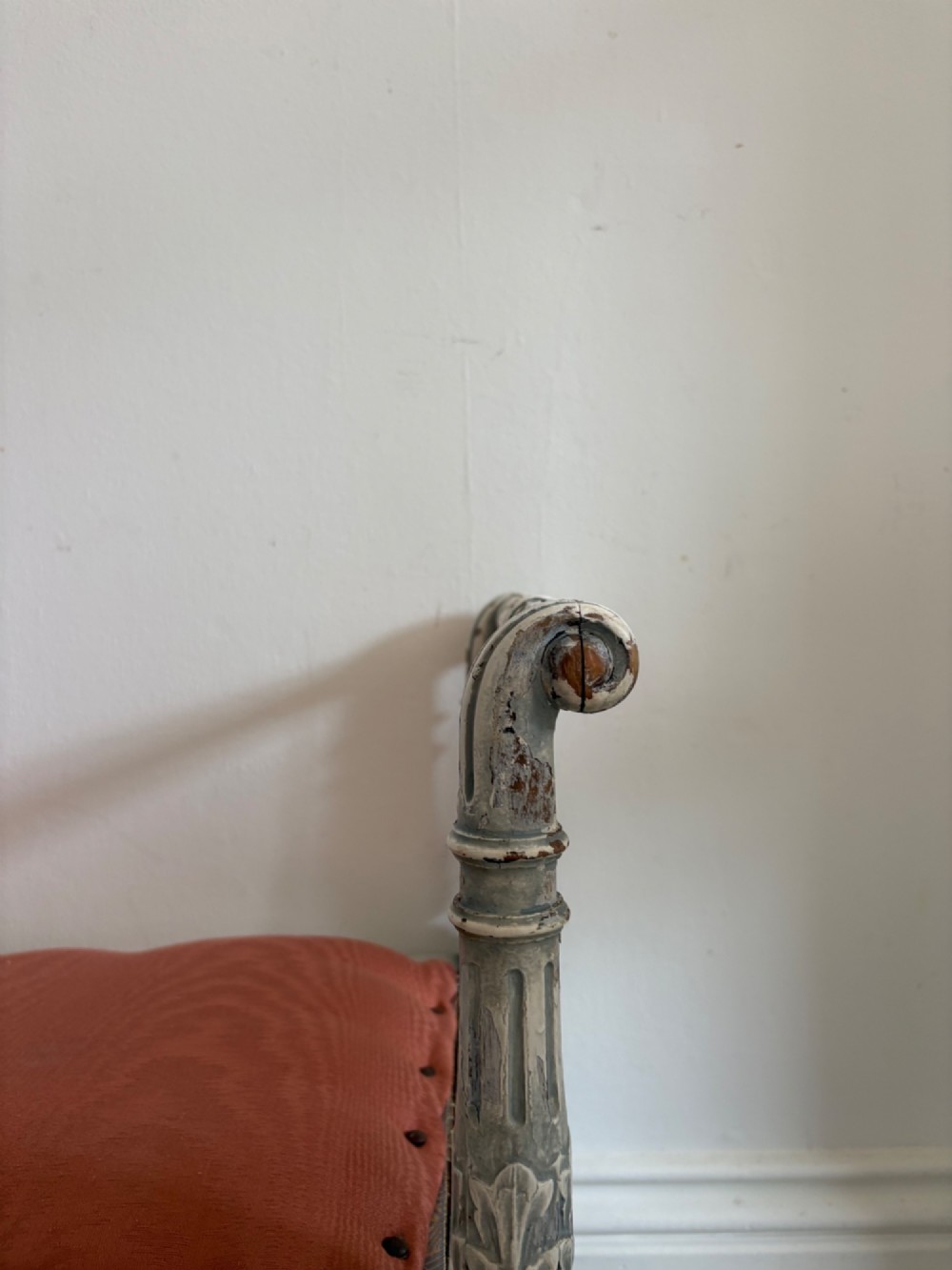 A white painted Gustavian style stool featuring raised side handles, fluted legs, and a terracotta silk upholstered seat. View XIII