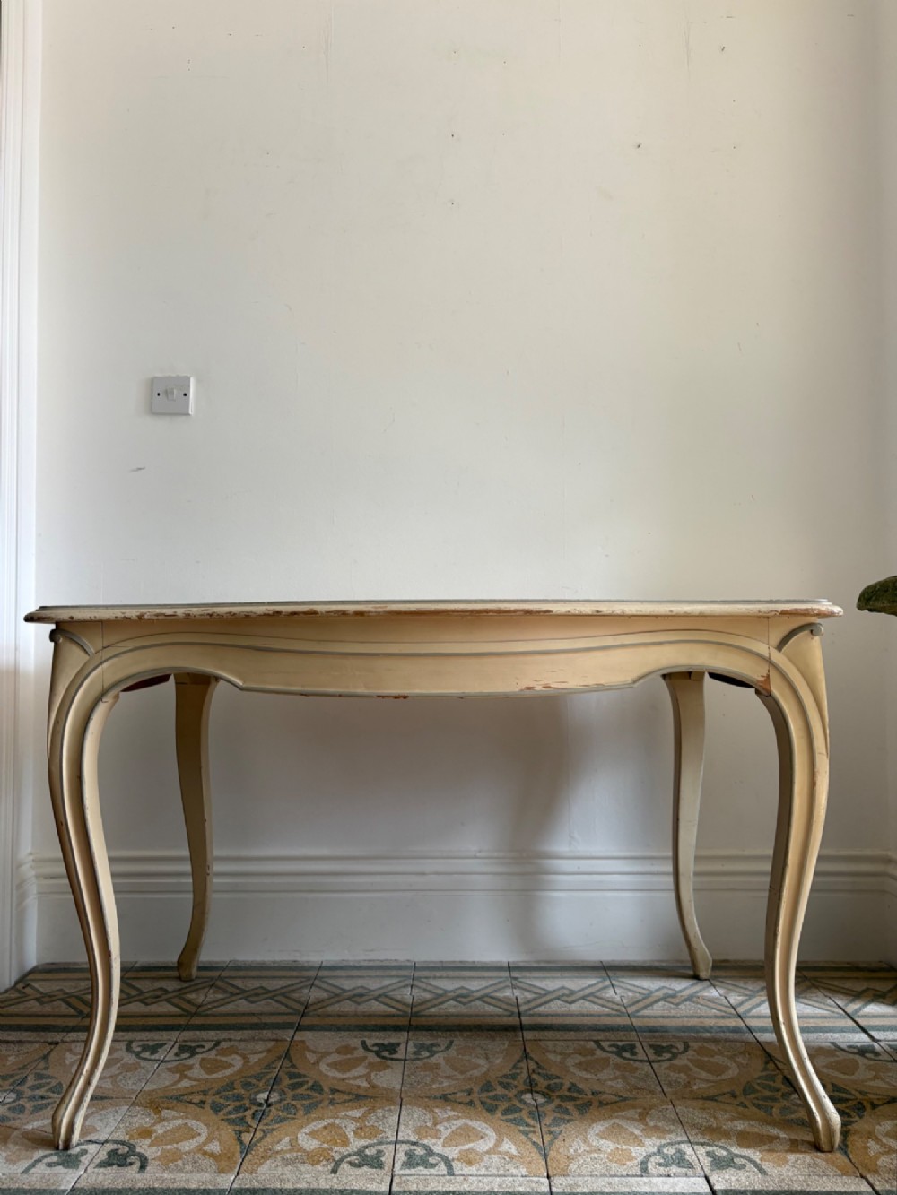 A cream painted French console table featuring long cabriole legs, a shaped apron with subtle trim, and an inset suede tabletop.