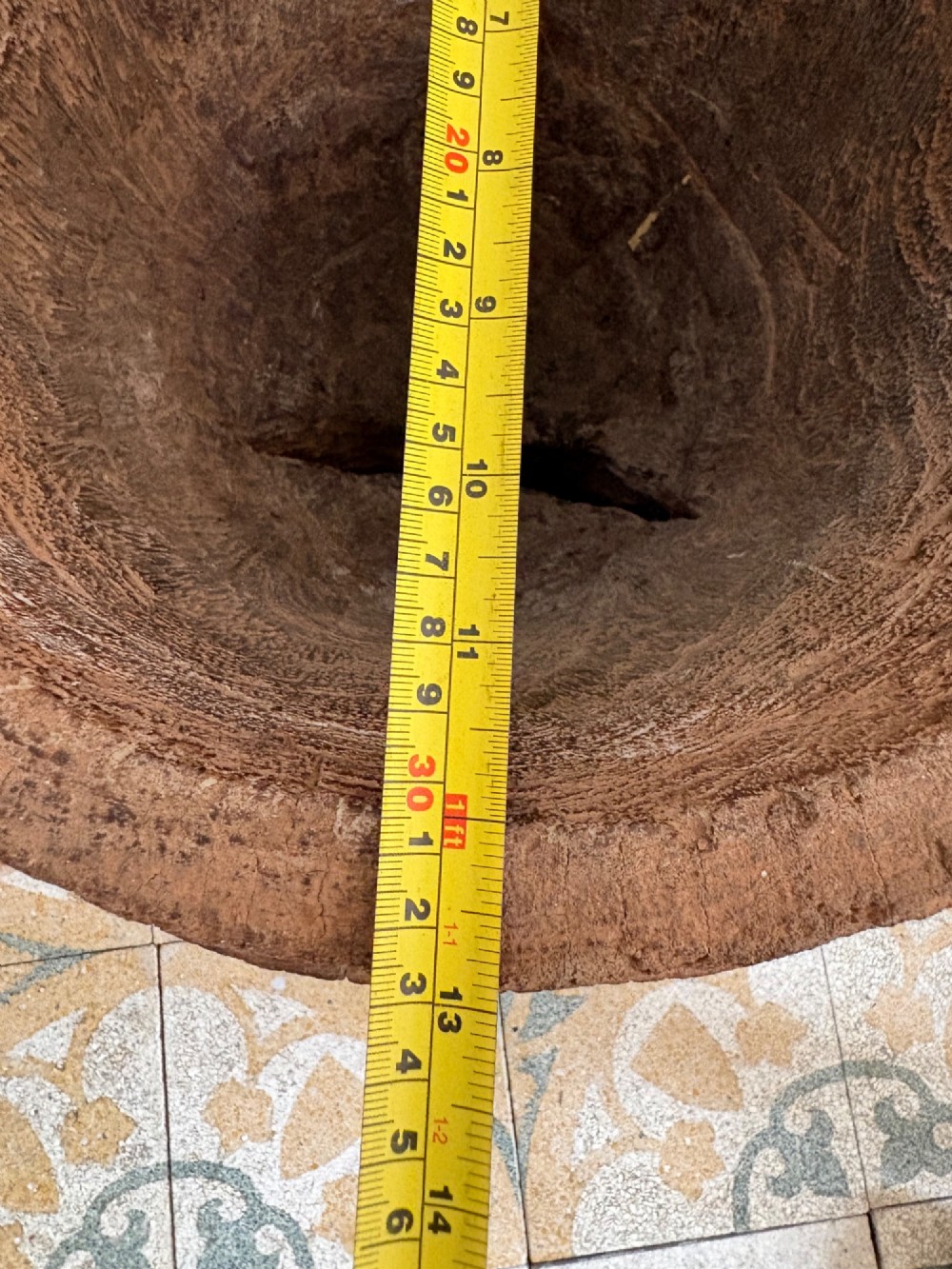 A hand-carved African hardwood grain mortar with side loop handles and concentric carved grooves, next to a tall wooden pestle pole. View XIV