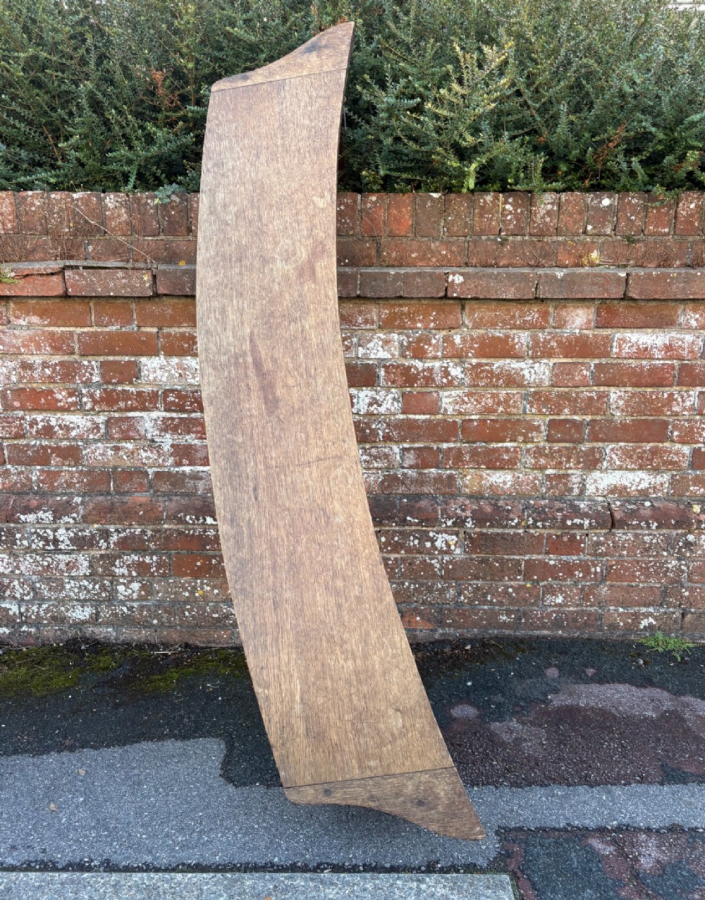 A long curved oak bench featuring trefoil carved cut-outs on the end supports. View V