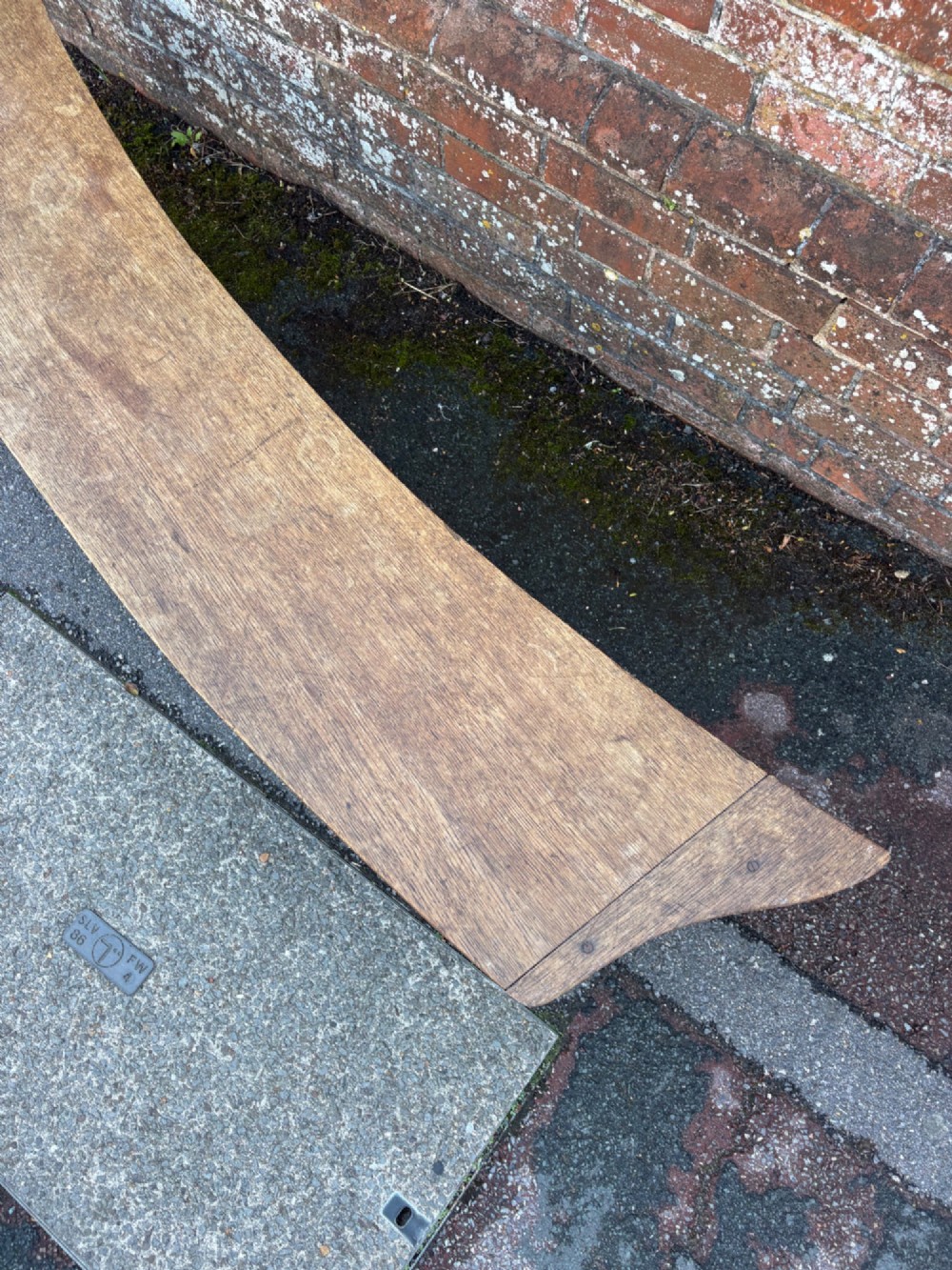 A long curved oak bench featuring trefoil carved cut-outs on the end supports. View VII