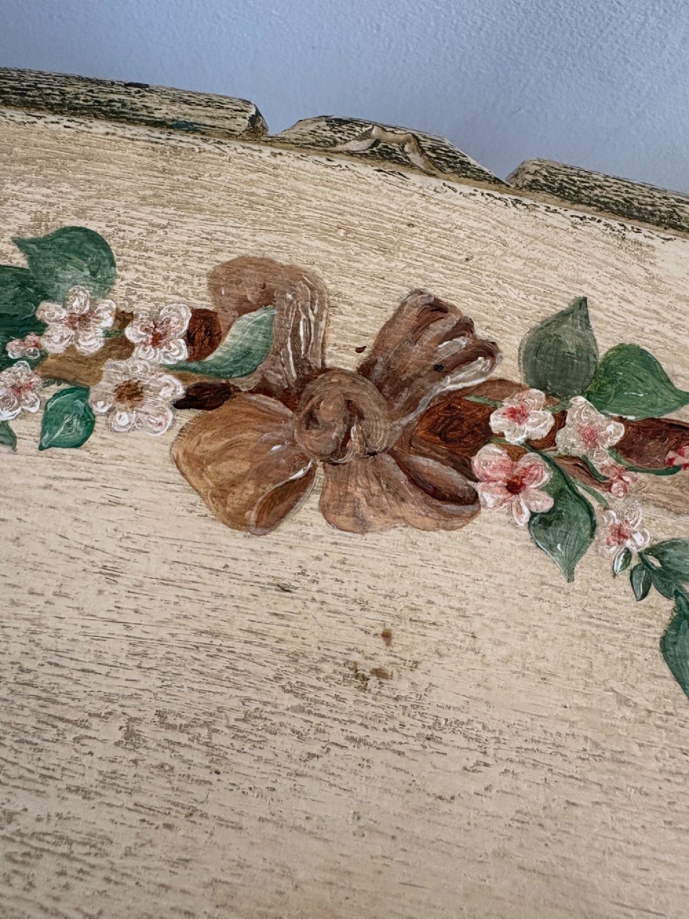An oval cream-painted mahogany occasional table with hand-painted floral garlands, fluted apron, and square tapered fluted legs. View X