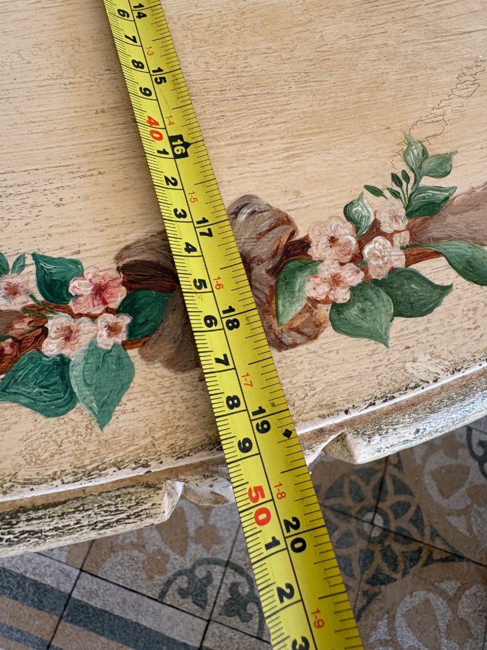 An oval cream-painted mahogany occasional table with hand-painted floral garlands, fluted apron, and square tapered fluted legs. View XV
