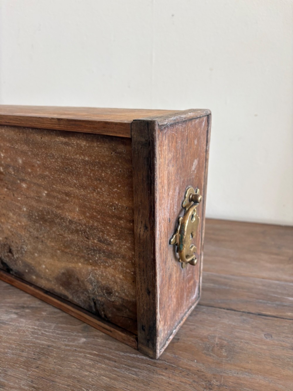 An early eighteenth-century oak lowboy side table featuring one wide upper drawer, two small side drawers, an arched apron, brass handles, and straight square legs. View VIII