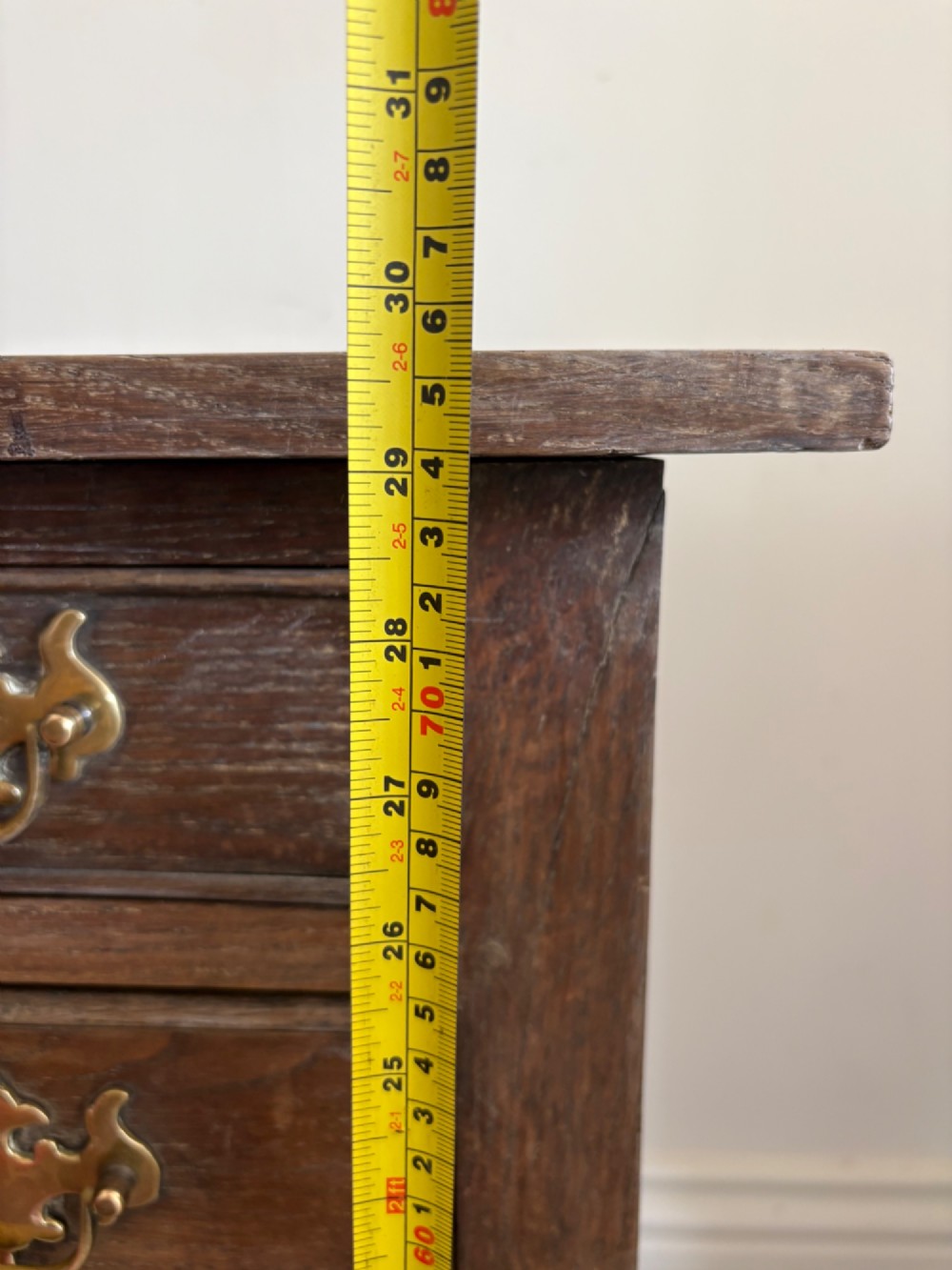An early eighteenth-century oak lowboy side table featuring one wide upper drawer, two small side drawers, an arched apron, brass handles, and straight square legs. View XV