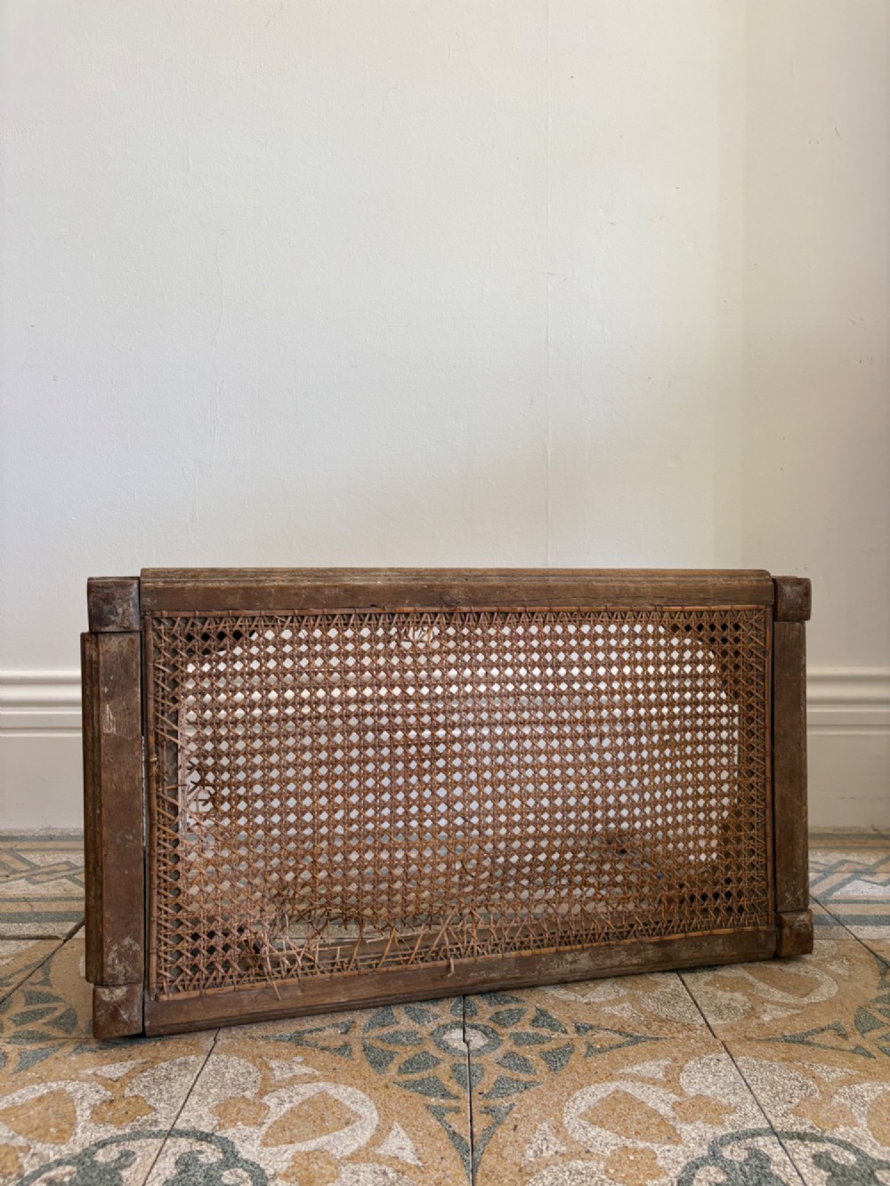 A French Neoclassical rectangular stool featuring a distressed white painted finish, fluted tapered legs, carved rosette corner details, and a woven cane seat. View XII