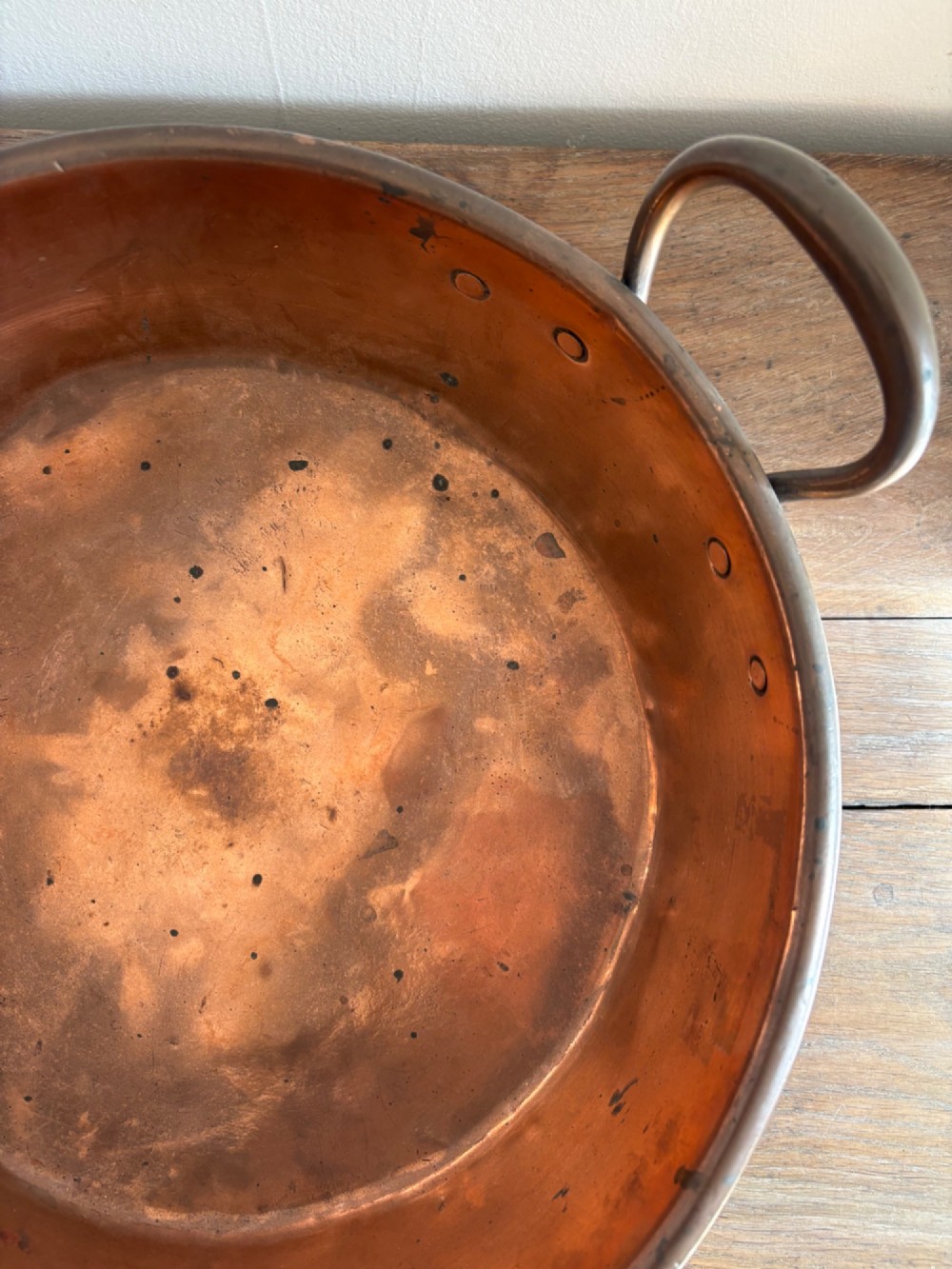 A large 19th-century polished copper preserve pan featuring twin riveted brass handles. View VI