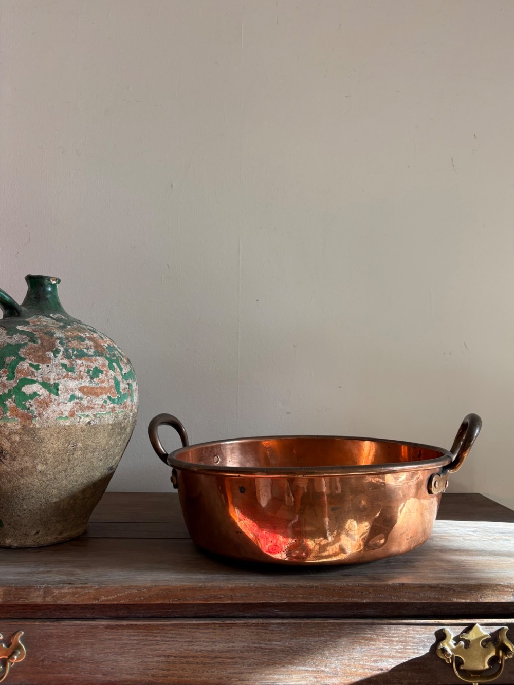 A large 19th-century polished copper preserve pan featuring twin riveted brass handles. View IX