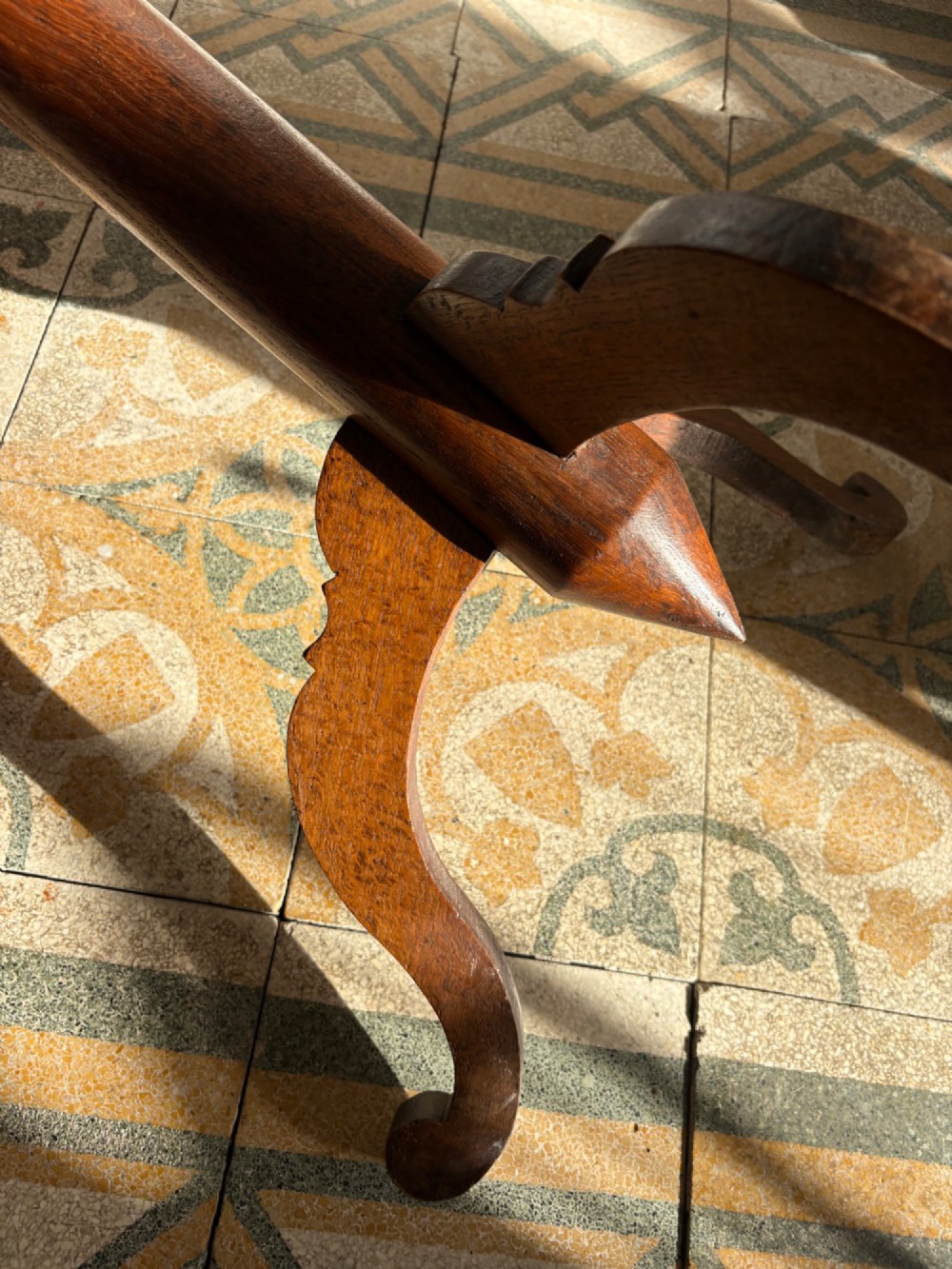 An English Arts and Crafts solid oak wine table featuring a circular top, an under-top support bracket, a central column terminating in a pointed lower finial, and three splayed cabriole legs. View XI