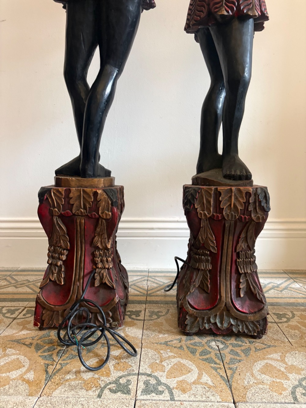 A pair of life-sized Venetian carved wood figure floor lamps featuring gilt and polychrome details, mounted on ornate pedestals with multi-light metal candelabra tops. View IV