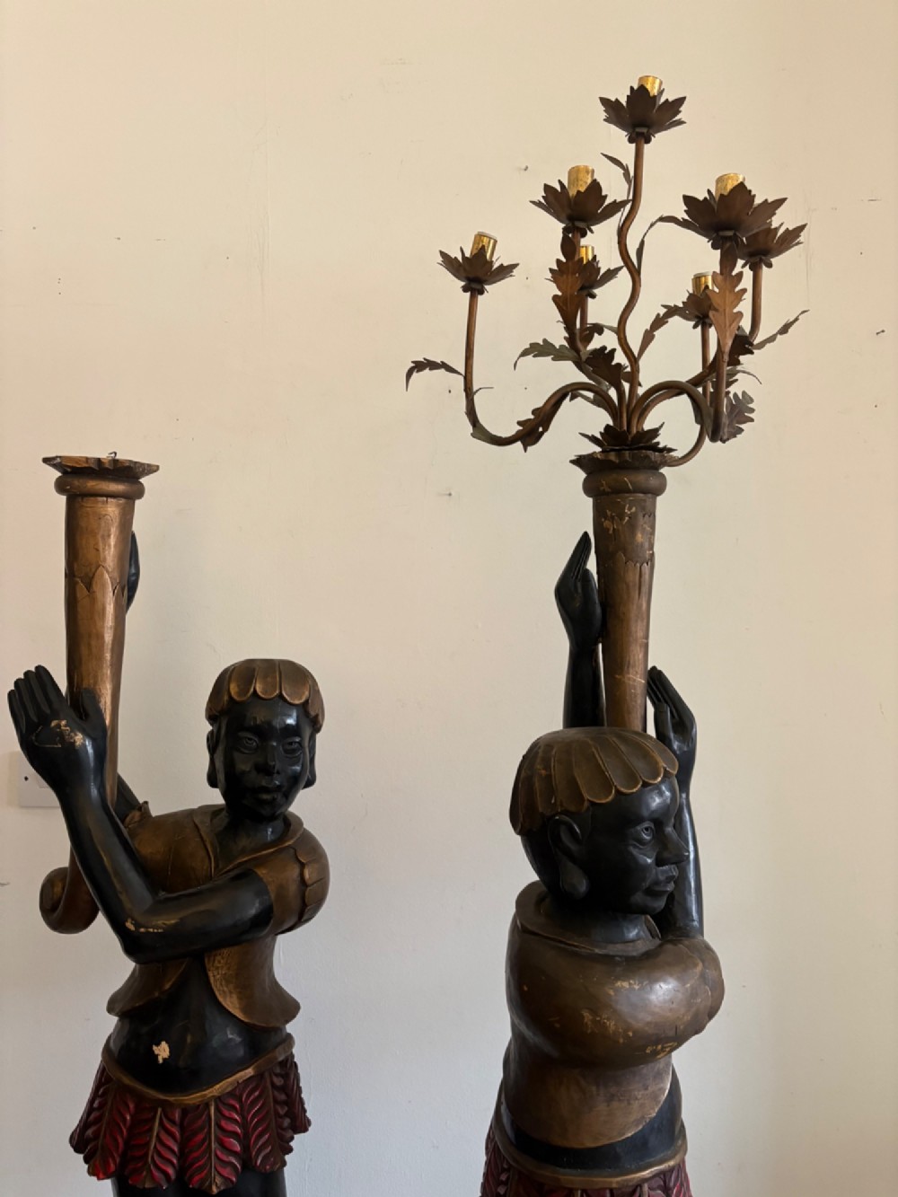 A pair of life-sized Venetian carved wood figure floor lamps featuring gilt and polychrome details, mounted on ornate pedestals with multi-light metal candelabra tops. View V