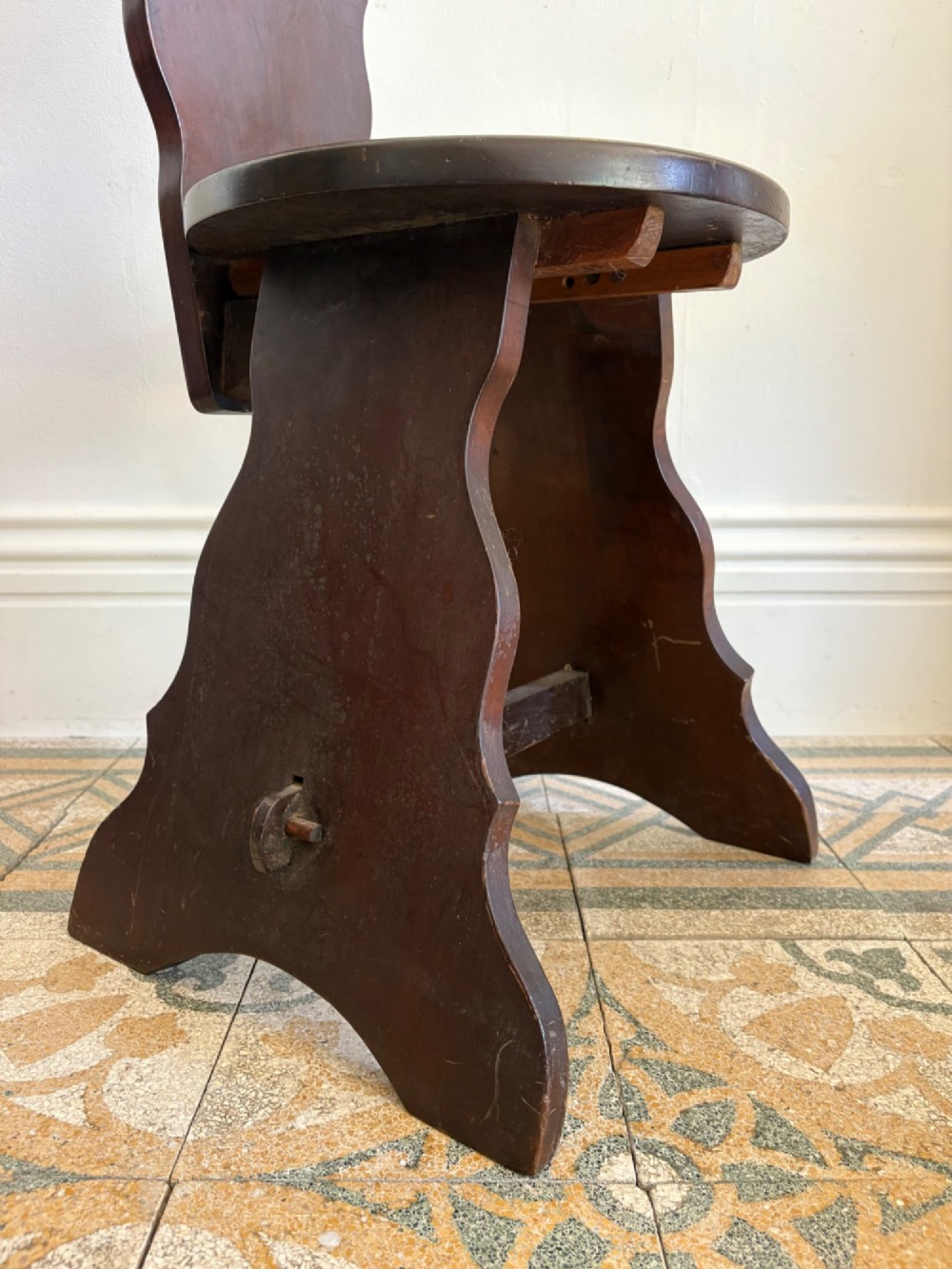 An Arts and Crafts dark mahogany hall chair featuring a shaped backrest with a pierced heart cutout and splayed legs. View VII