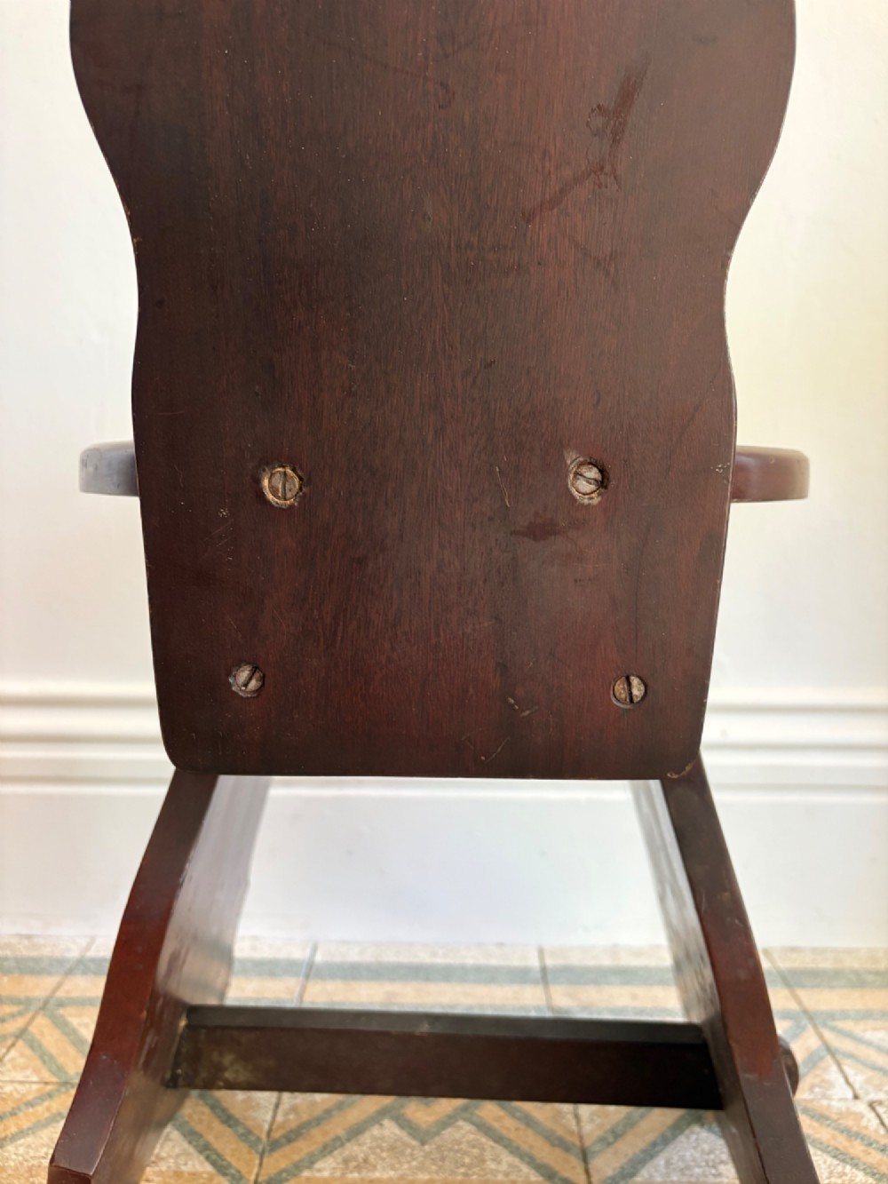 An Arts and Crafts dark mahogany hall chair featuring a shaped backrest with a pierced heart cutout and splayed legs. View X