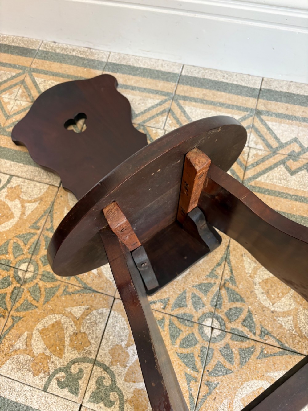 An Arts and Crafts dark mahogany hall chair featuring a shaped backrest with a pierced heart cutout and splayed legs. View XI
