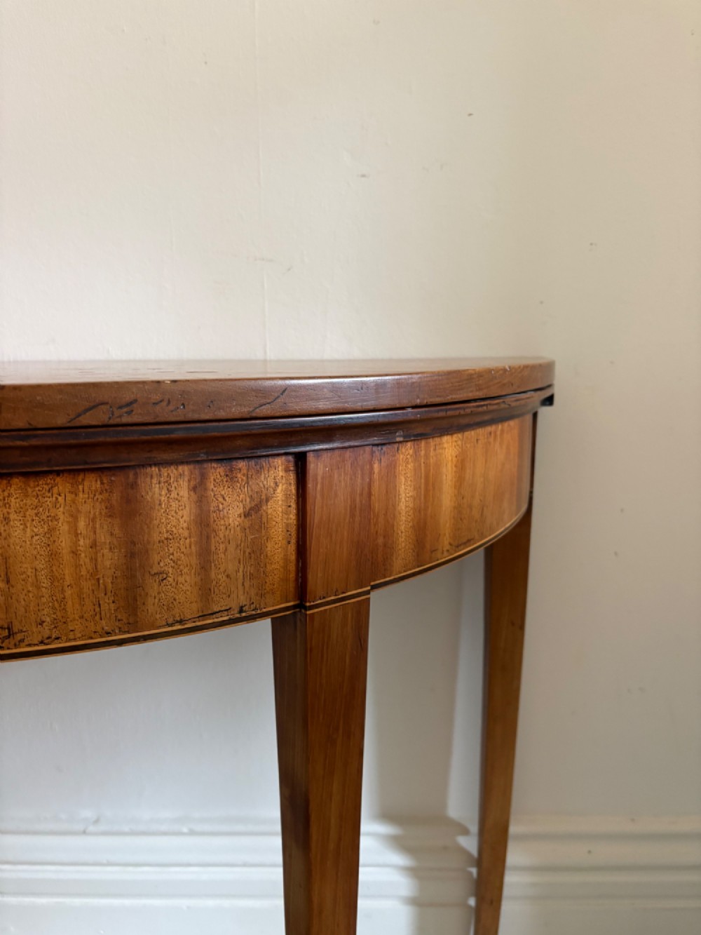 A late 18th-century George III semi-circular demi-lune folding table crafted from cherrywood and elm with four tapered square legs. View II