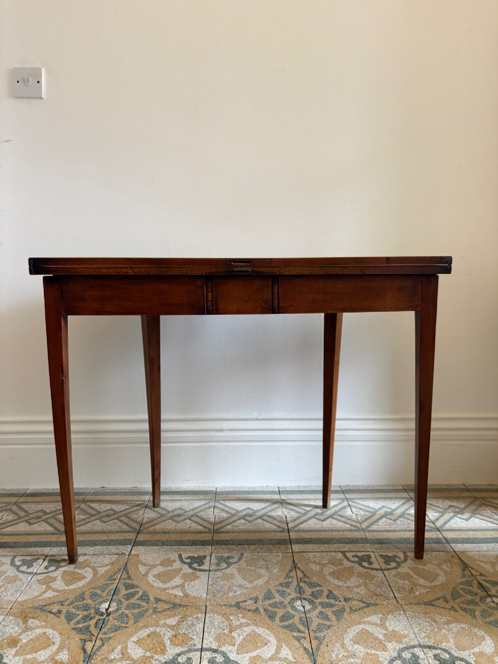 A late 18th-century George III semi-circular demi-lune folding table crafted from cherrywood and elm with four tapered square legs. View X
