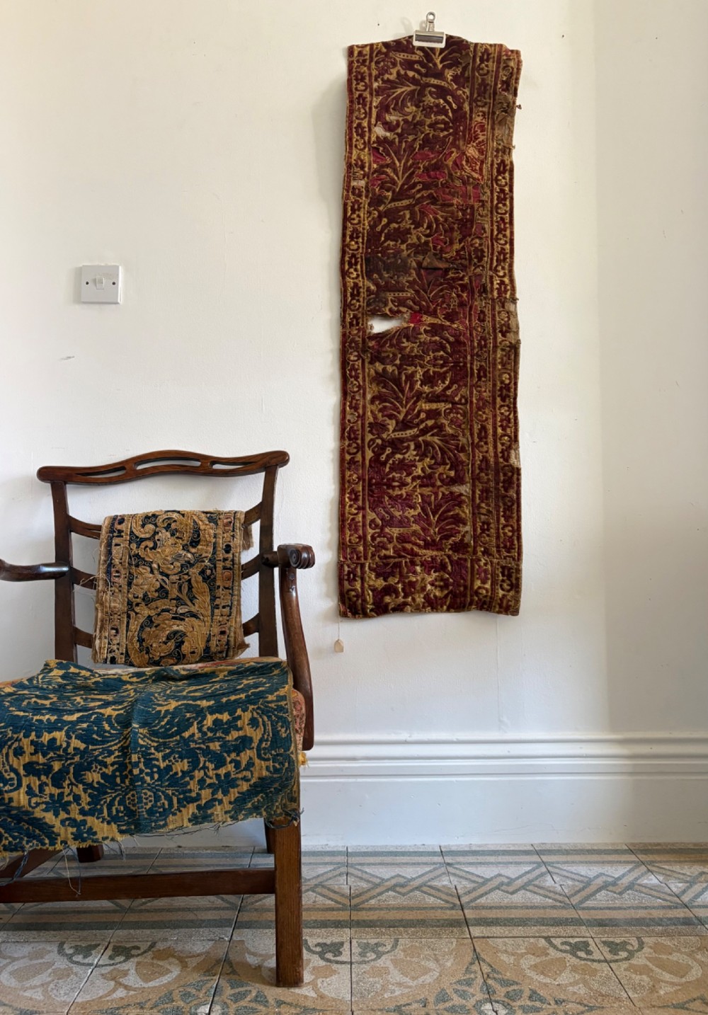 A long vertical 17th-century Italian crimson velvet textile fragment with gold silk acanthus leaf embroidery and patterned borders. View VIII