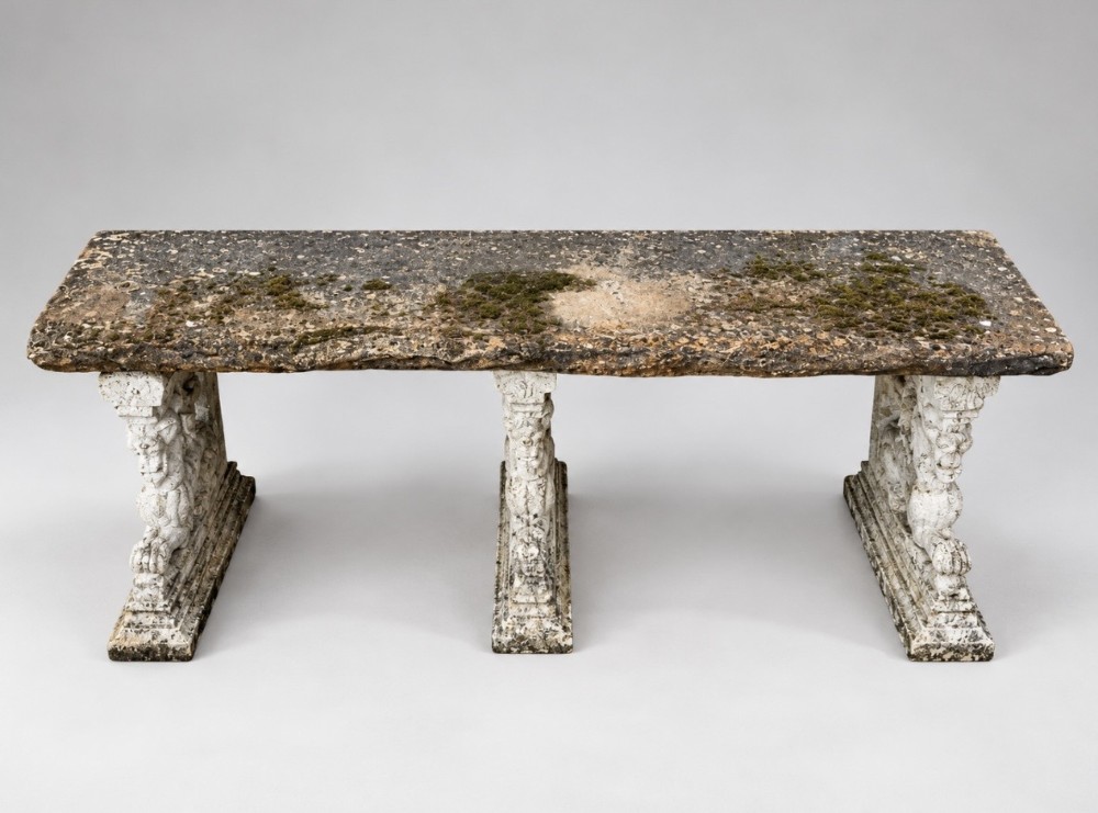 A weathered stone garden bench featuring a rectangular York stone top resting on three cast stone griffin pedestals. View III