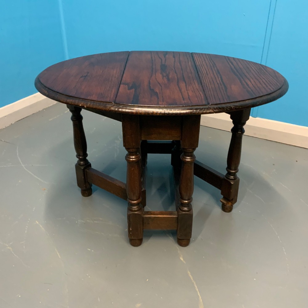 A dark oak gateleg side table featuring turned baluster legs, base stretchers, and hinged drop-leaf sides. View II