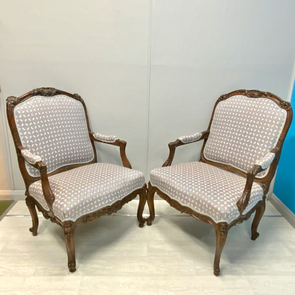Very near pair of French walnut open armchairs