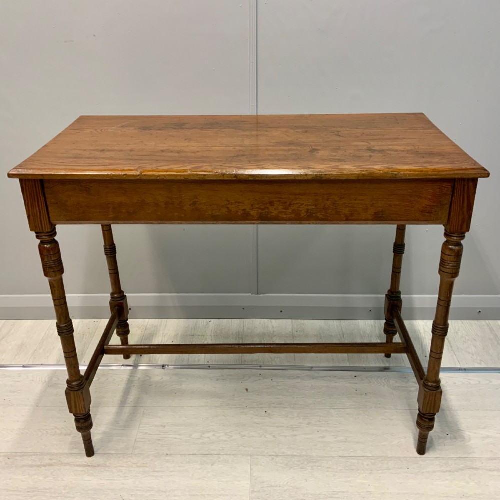 A nineteenth-century pitch pine side table featuring turned legs connected by a low stretcher base and a rectangular wooden top. View II