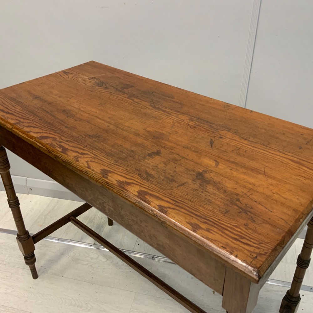 A nineteenth-century pitch pine side table featuring turned legs connected by a low stretcher base and a rectangular wooden top. View III