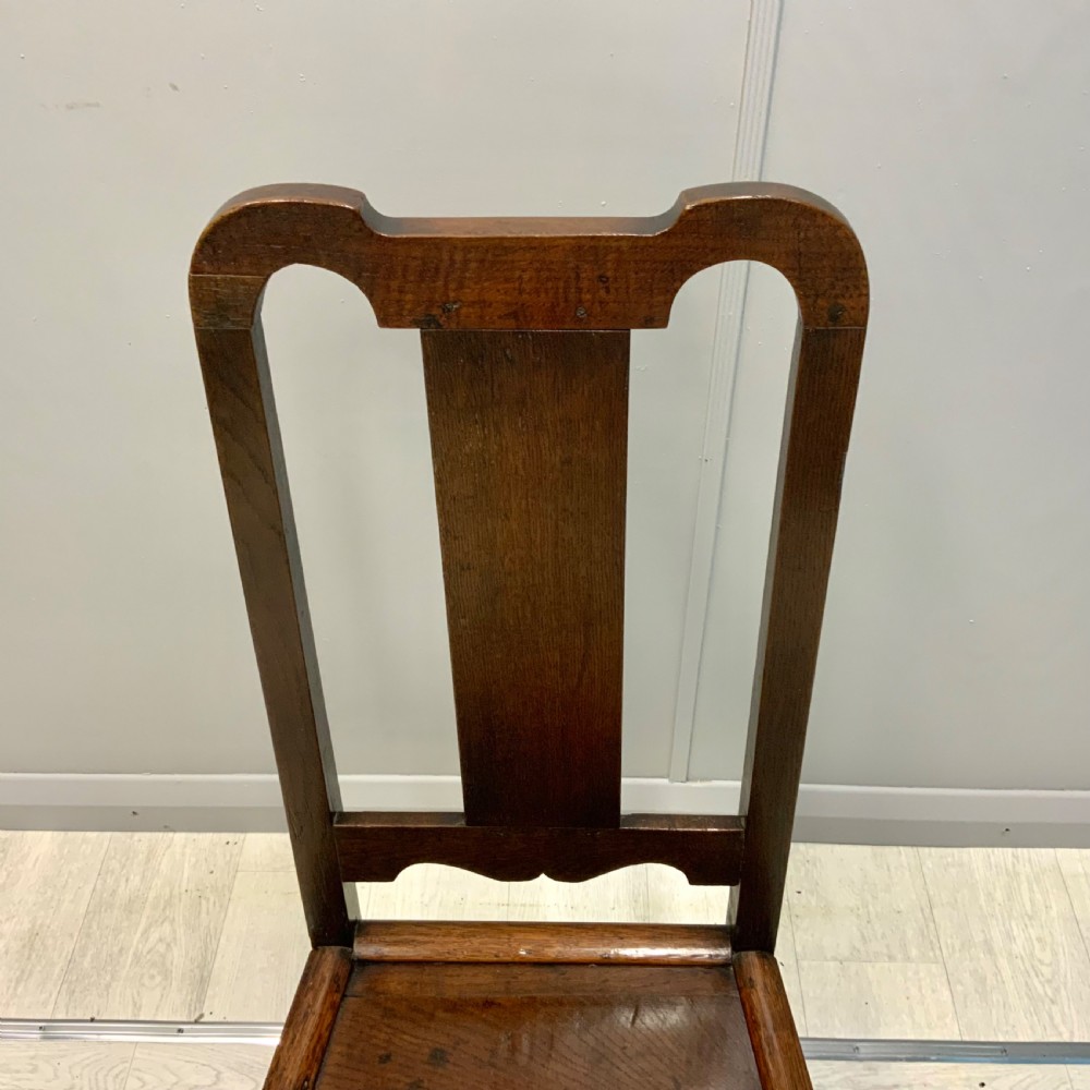 A late 17th-century dark oak back stool side chair featuring a solid wooden seat, central back splat, and turned front legs with stretchers. View IV